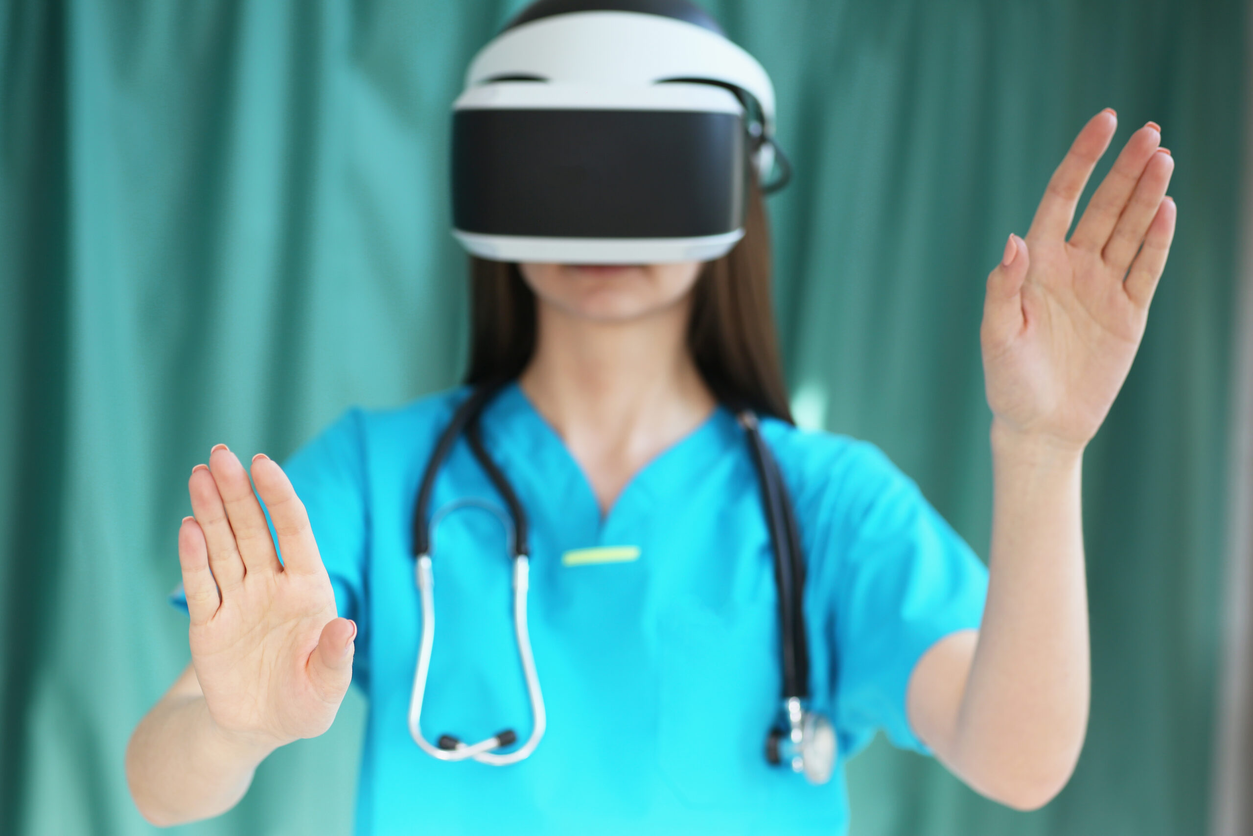 Profesional de la salud con uniforme azul utiliza gafas de realidad virtual para entrenamiento médico.